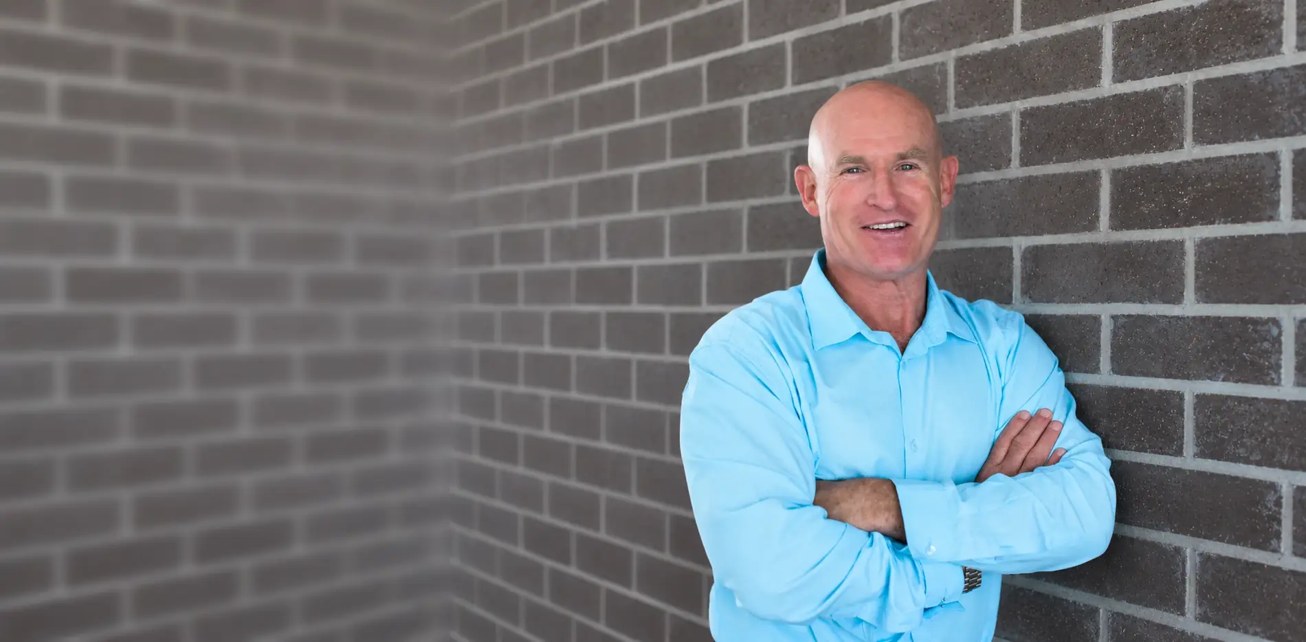 Dr Mal McKay, acupuncturist, smiling with arms folded