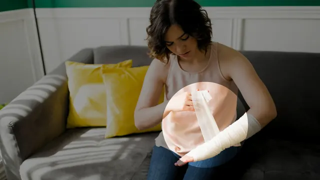 A woman on a sofa wrapping a bandage around her forearm