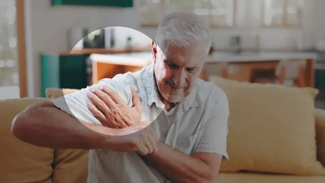 An older man holding a sore shoulder
